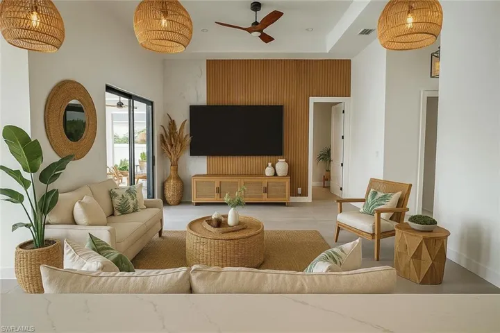 Living room featuring ceiling fan and an accent wall