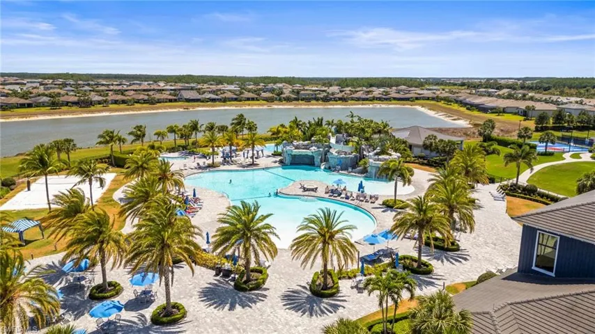 Aerial view of residential area featuring a pool area and a nearby body of water