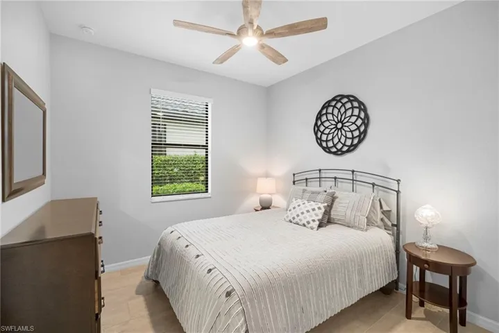 Bedroom with ceiling fan and light tile patterned floors