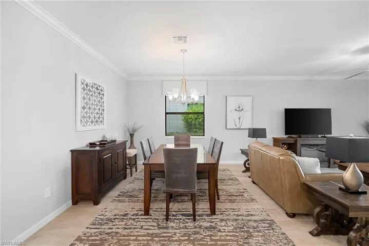 Dining space featuring crown molding and a chandelier