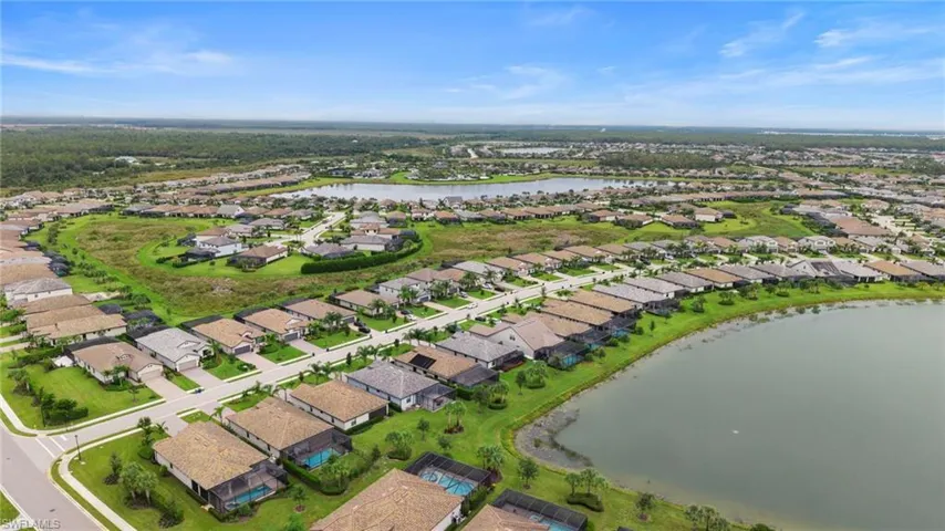 Aerial view of property's location with a nearby body of water and nearby suburban area