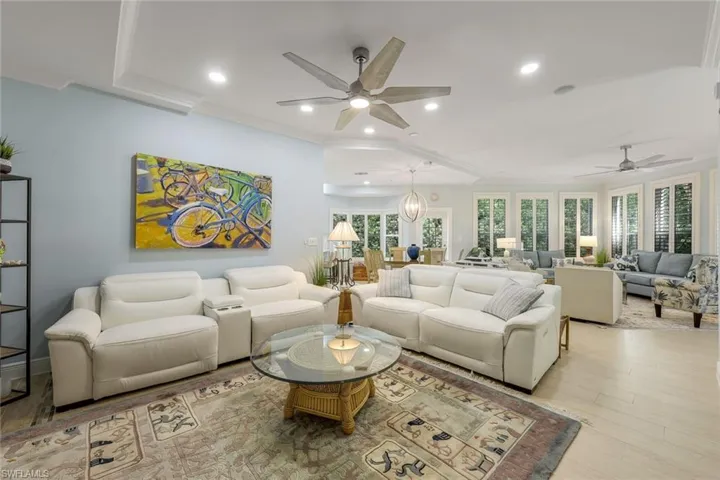 Living area featuring crown molding, ceiling fan, recessed lighting, and wood finished floors