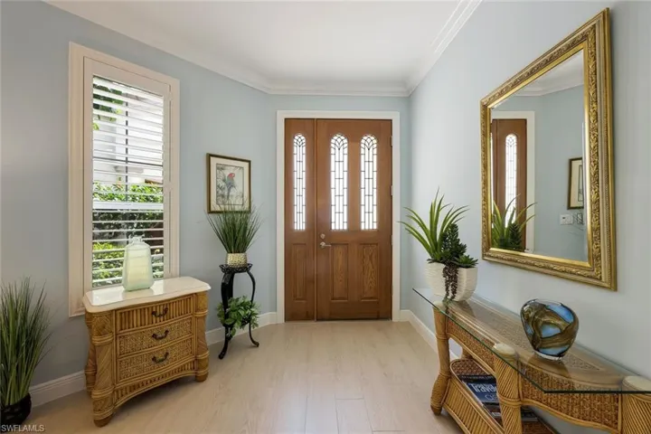 Entryway featuring crown molding and light wood-style floors
