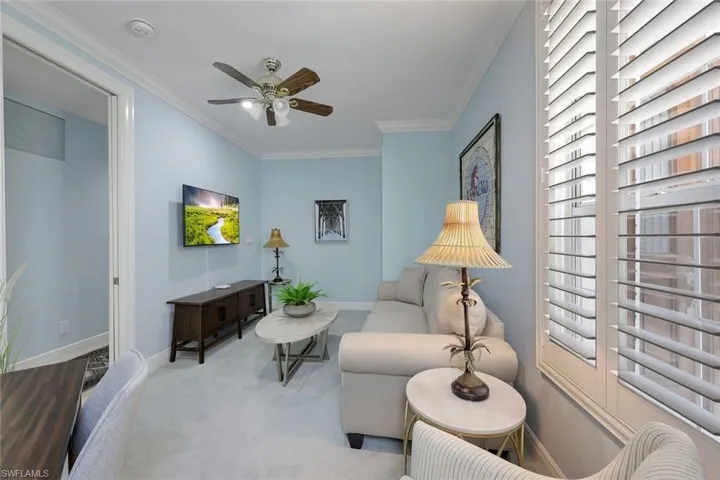 Sitting room featuring ornamental molding, carpet flooring, and ceiling fan