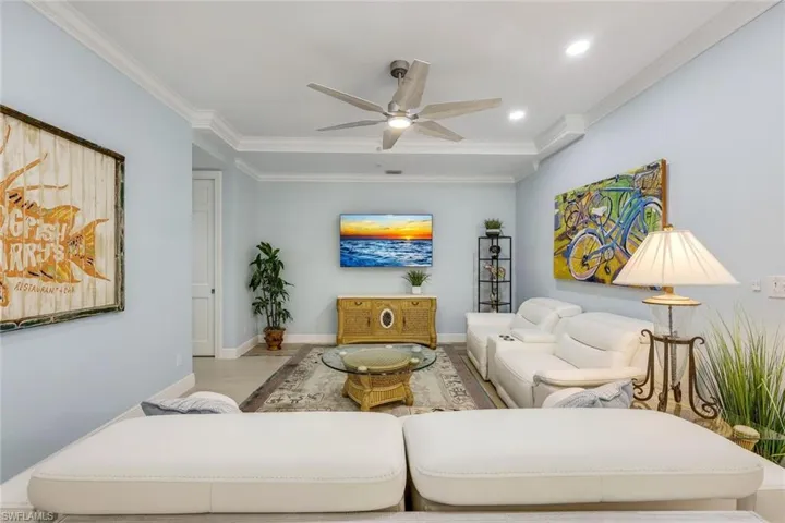 Living room with crown molding, wood finished floors, ceiling fan, and recessed lighting