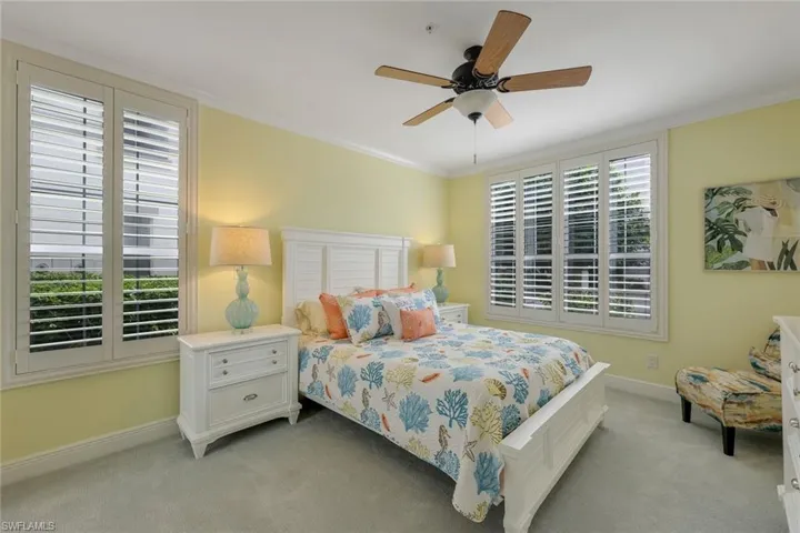 Carpeted bedroom with crown molding and ceiling fan