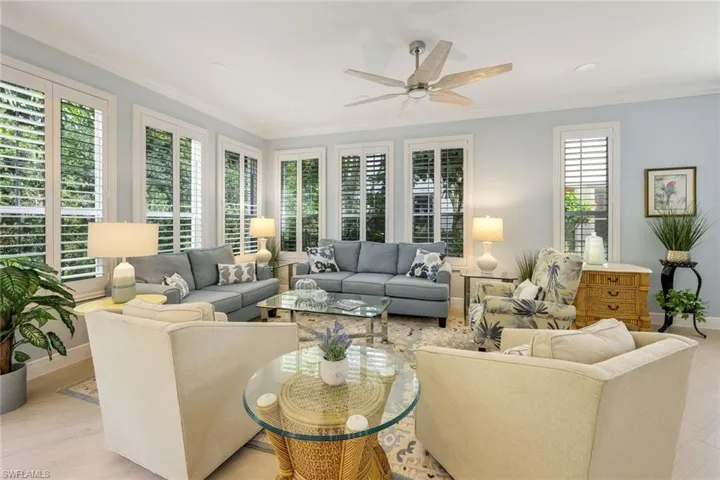 Living area with ornamental molding, wood finished floors, and a ceiling fan