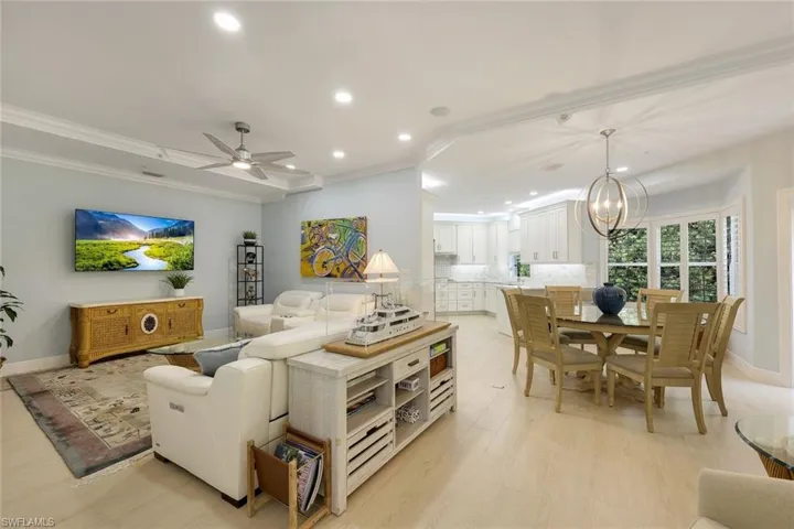 Living area with recessed lighting, crown molding, a chandelier, a ceiling fan, and light wood-type flooring