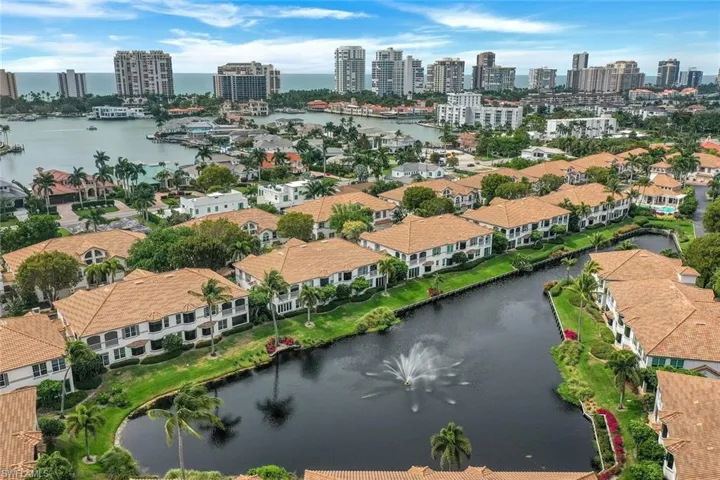 Aerial view of property and surrounding area with a nearby body of water and city skyline
