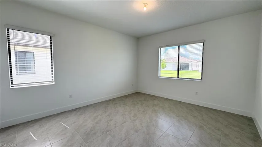 Unfurnished room with baseboards and light tile patterned floors