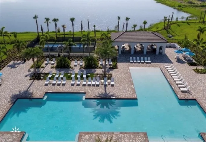 Community pool with a water view and a patio