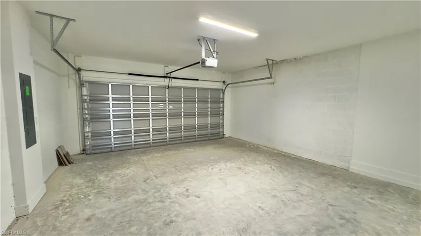 Garage with electric panel and a garage door opener