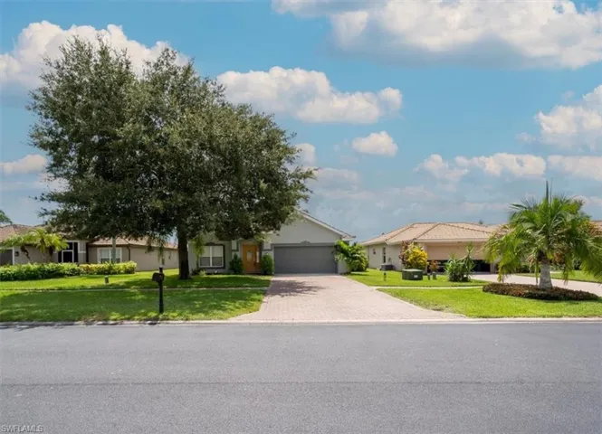 View of front of home with a garage and a front lawn