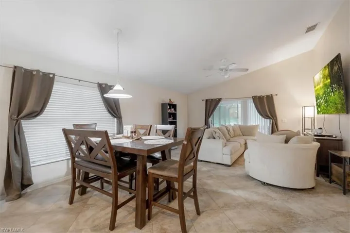 Dining area featuring light tile patterned flooring, lofted ceiling, and ceiling fan
