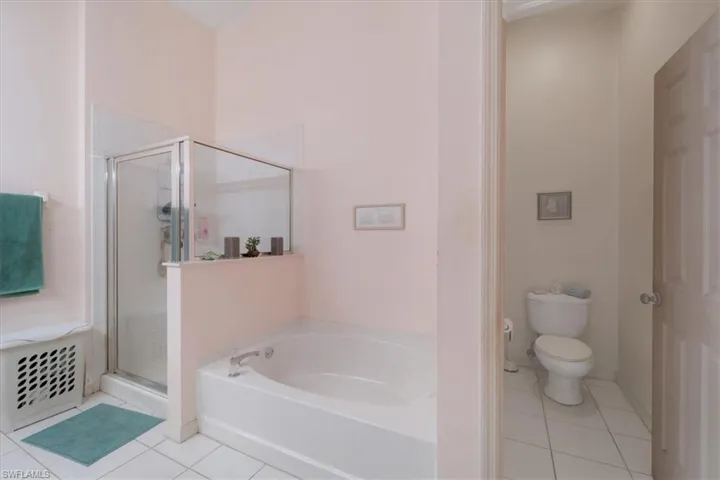 Bathroom featuring toilet, tile patterned floors, and separate shower and tub