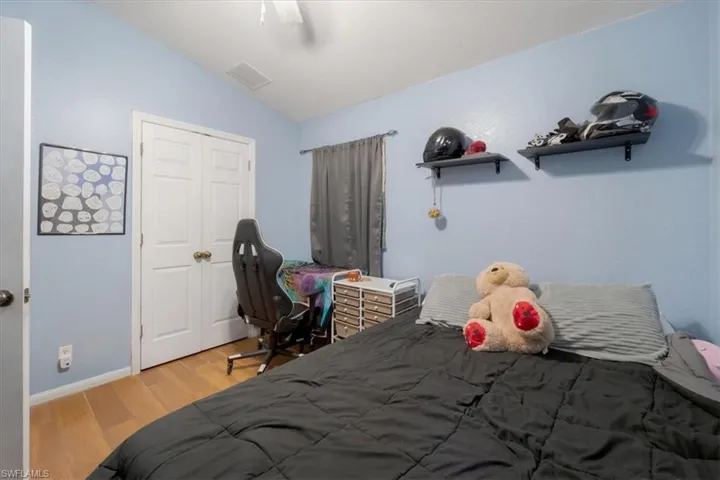 Bedroom with lofted ceiling, wood-type flooring, and ceiling fan