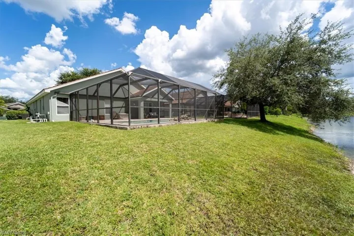 View of yard featuring a swimming pool and glass enclosure