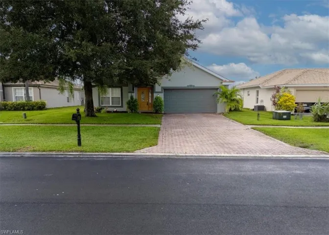 Single story home featuring a garage and a front lawn
