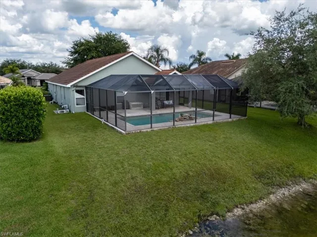 Back of property with a lanai, a patio, and a yard