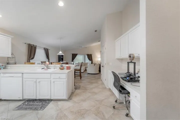 Kitchen featuring sink, white cabinets, white dishwasher, and light tile patterned floors