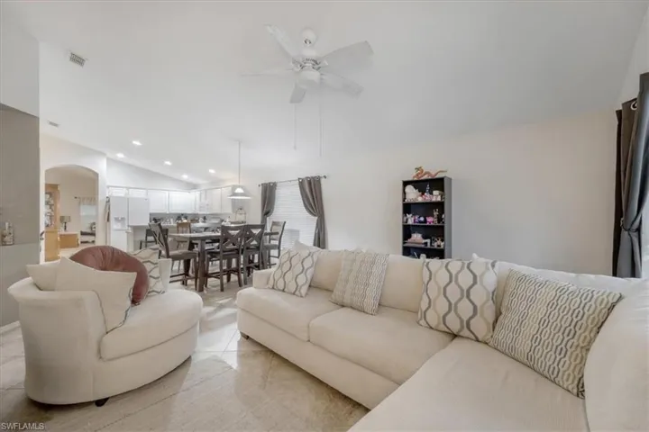 Tiled living room featuring vaulted ceiling and ceiling fan