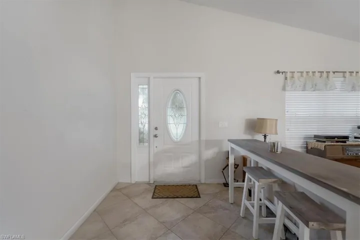 Tiled foyer with vaulted ceiling