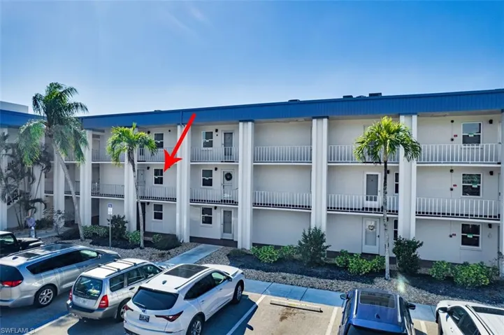 View of apartment building / complex with uncovered parking