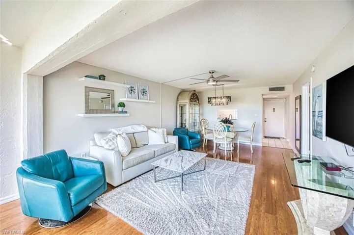 Living area with light wood finished floors and a ceiling fan