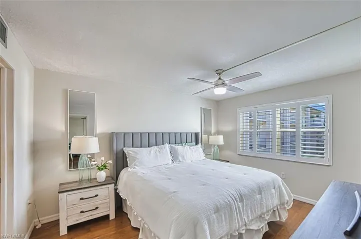 Bedroom featuring wood finished floors, ceiling fan, and a textured ceiling