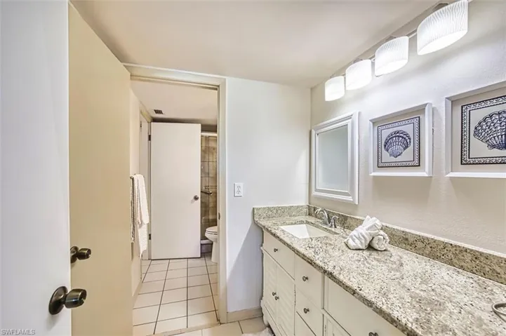 Full bath with vanity, a shower, and light tile patterned floors