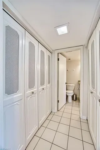 Bathroom with a closet and light tile patterned flooring