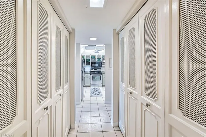 Hallway featuring light tile patterned flooring and a heating unit