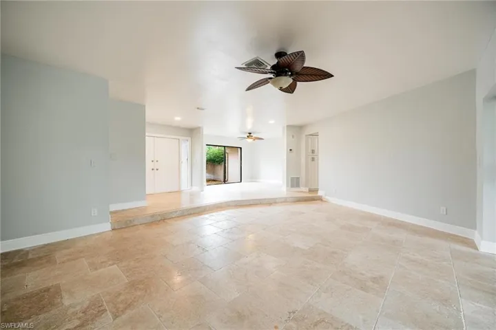 Unfurnished living room featuring ceiling fan