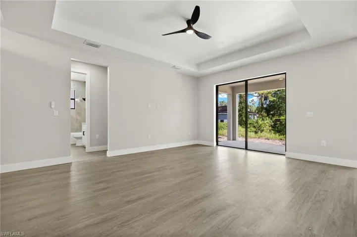 Spare room featuring ceiling fan, hardwood / wood-style flooring, and a tray ceiling