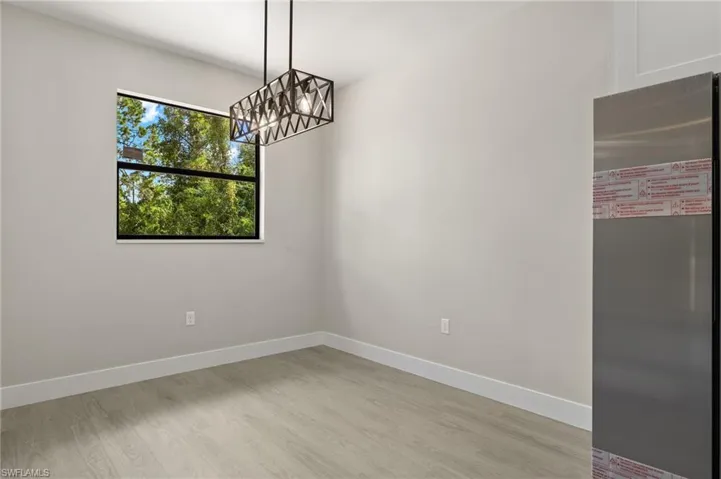 Empty room featuring an inviting chandelier and light hardwood / wood-style floors