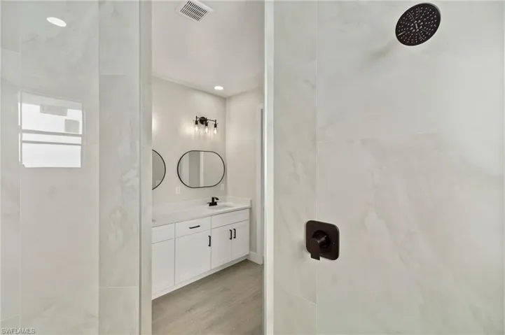 Bathroom with vanity, wood-type flooring, and walk in shower
