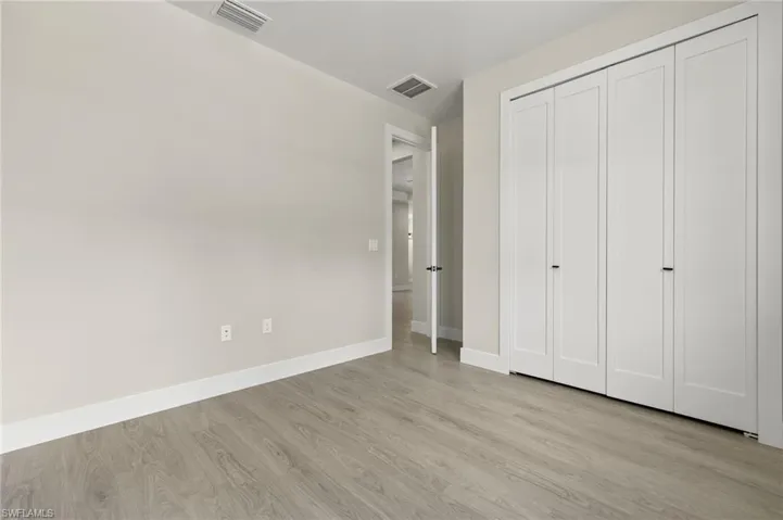 Unfurnished bedroom with a closet and light hardwood / wood-style floors