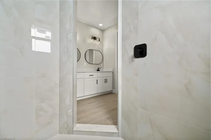 Bathroom featuring vanity, hardwood / wood-style floors, and a shower
