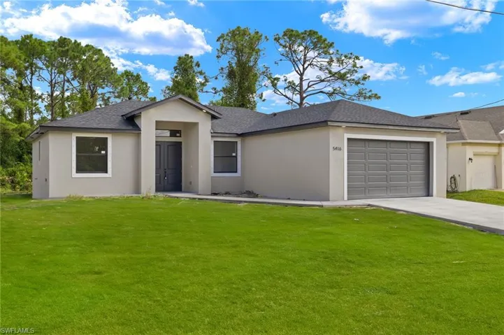 View of front facade featuring a garage and a front yard