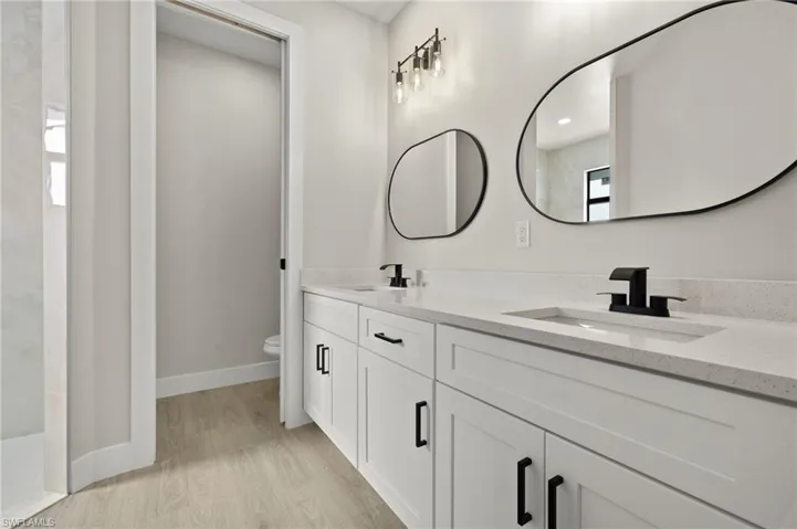 Bathroom featuring hardwood / wood-style floors, toilet, and vanity