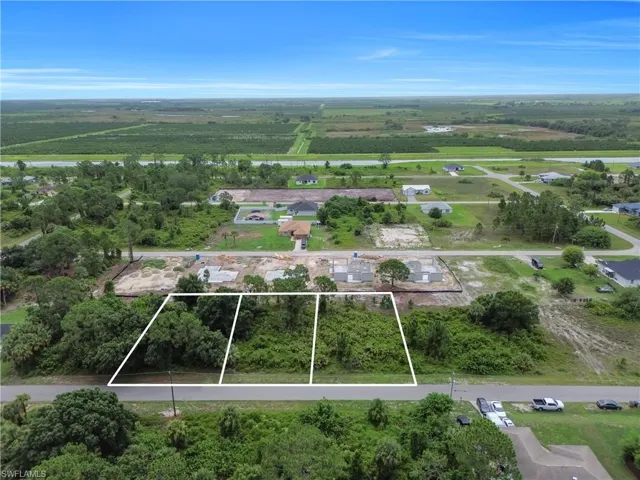 Aerial view of sparsely populated area featuring property parcel outlined and large plots for crops