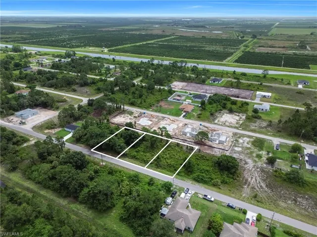 Aerial overview of property's location featuring a nearby body of water, rows of crops, and rural landscape