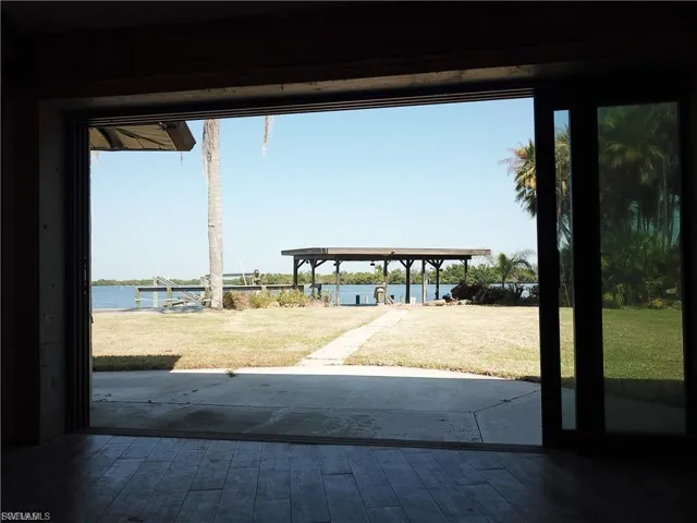 Dock area featuring a water view, a patio, and a yard