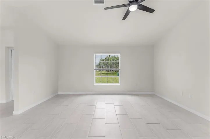 Spare room with ceiling fan and light tile patterned floors