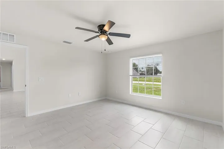 Unfurnished room with light tile patterned flooring and ceiling fan