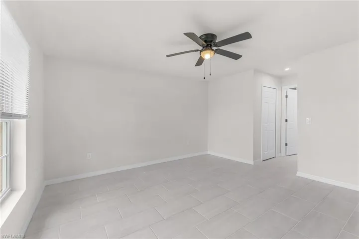 Tiled spare room with ceiling fan