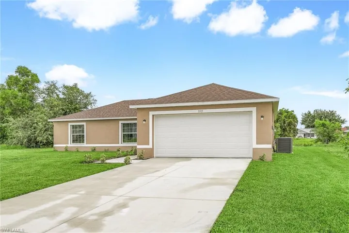 Ranch-style home with a garage, central AC unit, and a front yard