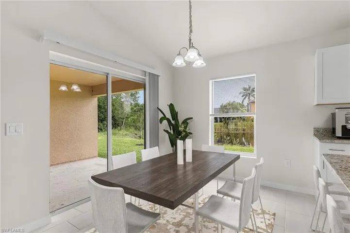 Dining space featuring a chandelier, lofted ceiling, and light tile patterned floors