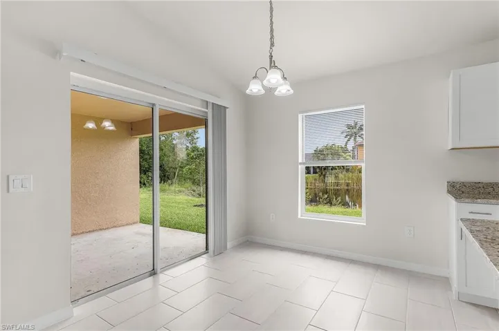 Unfurnished dining area with vaulted ceiling, a notable chandelier, and light tile patterned floors