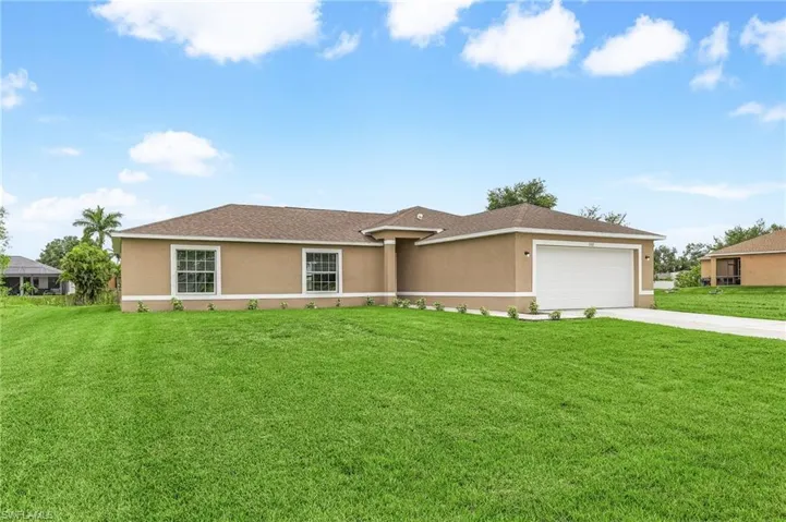 Single story home featuring a garage and a front yard